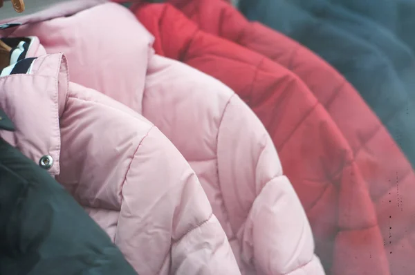 Nahaufnahme von bunten Winterjacken auf Kleiderbügeln im Modegeschäft — Stockfoto