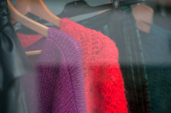 Primo piano di pullover di lana colorato sulle grucce in un negozio di moda donna — Foto Stock