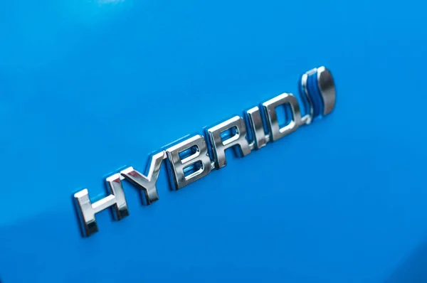 Segno ibrido sulla macchina blu Toyota parcheggiata in strada — Foto Stock