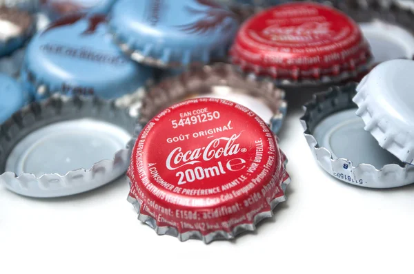 Использованные металлические колпачки Coca-Cola и Bier на белом фоне — стоковое фото