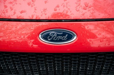  Caddeye park etmiş kırmızı Ford 'a yağmur damlaları yağıyor.