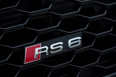 Sokakta park etmiş arabanın önünde 6 Rupi yazıyor. 