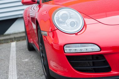  Kırmızı Porsche 911 'in ön ışığı sokağa park edilmiş.