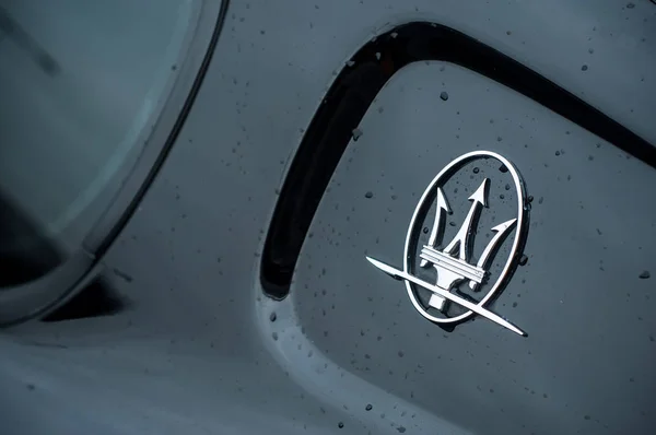 Maserati logo on black sport car parked in the street — ストック写真