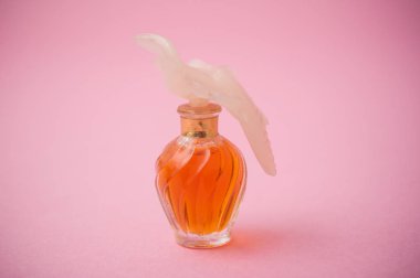 Nina Ricci pembe arka planda lüks parfüm şişesi