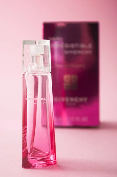 Непереборні парфуми в рожевій мініатюрній пляшці на рожевому тлі. — стокове фото