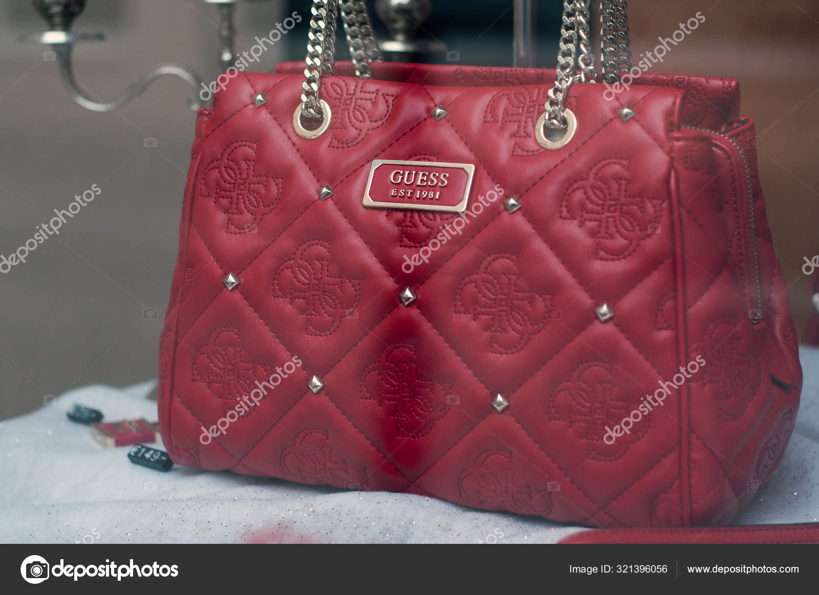 Red leather handbag by Guess the famous brand in a luxury fashinstore showroom – Stock Editorial Photo © NeydtStock #321396056