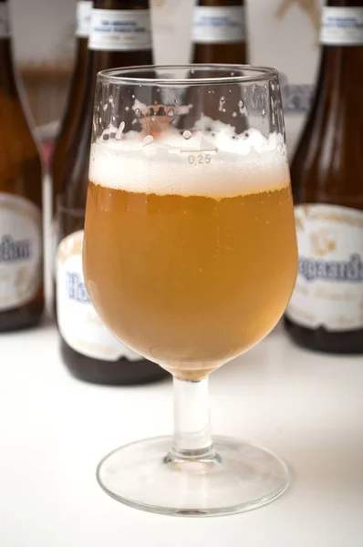 Belgischer Hoegaarden von Weißbier im Glas auf Flaschenhintergrund — Stockfoto