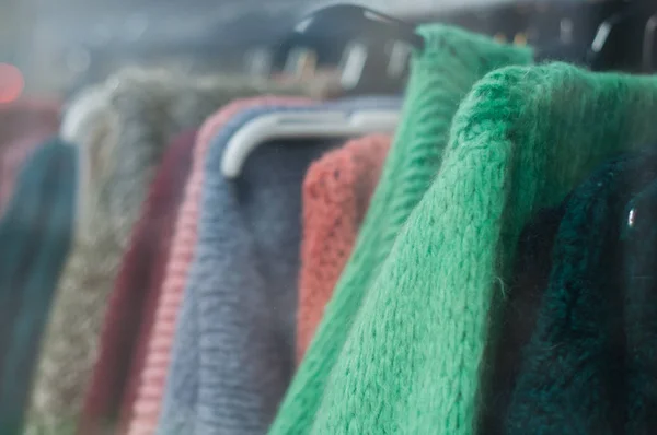 Крупним планом барвистий вовняний пуловер на вішалках — стокове фото