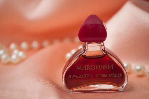 Духи Maroussia в миниатюрной бутылке на атласном фоне — стоковое фото