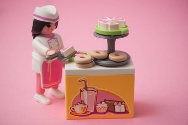 Pembe arka planda hamur işi kostümlü oyuncak bebek