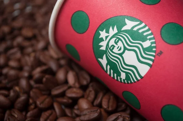 Boldog karácsonyt elvenni csésze által Starbucks márka kávébab háttér, Starbucks a híres lánc a gyorsétterem — Stock Fotó