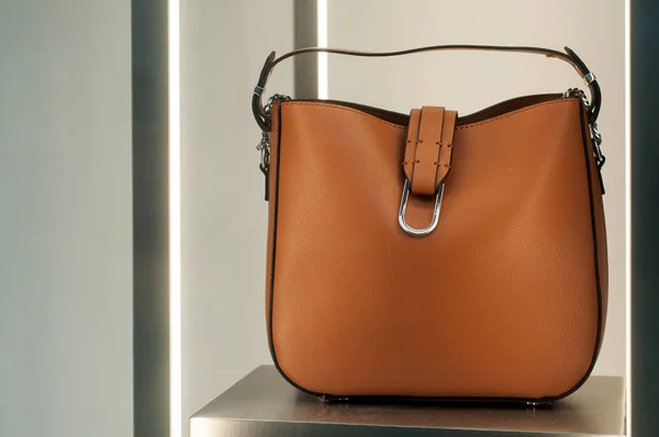 Крупный план коричневой кожаной сумочки в салоне модного магазина — стоковое фото