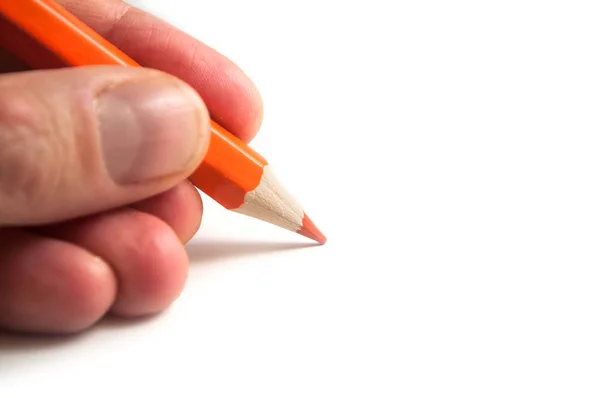 Detailní záběr oranžové tužky barvy v ruce na bílém pozadí — Stock fotografie