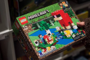 Sarı lego kutulu minecraft oyuncakçı dükkanındaki kadının elinde.