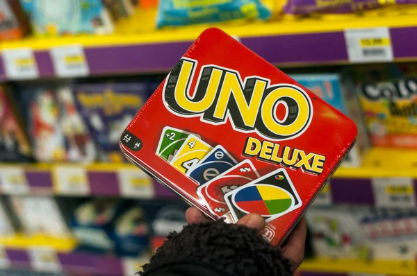 Un juego de cartas en la mano de la mujer en un supermercado tienda de juguetes —  Fotos de Stock
