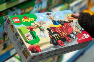 Oyuncak mağazasındaki bir kadının elinde lego duplo 'dan oyuncak hikaye treni
