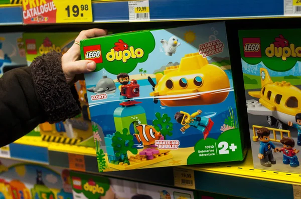 Желтая подлодка lego duplo коробка в руке женщины в магазине игрушек супермаркет — стоковое фото