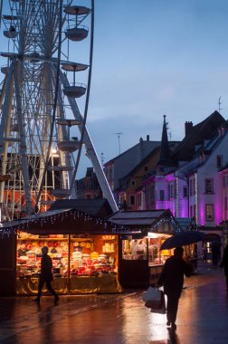 Ana caddedeki noel pazarının ışıklandırmaları ve arka planda büyük tekerlekler.  