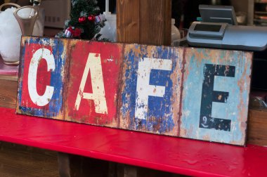 Caddedeki barda poz veren eski model kahve tabelasının yakın çekimi.