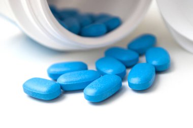 Plastik şişeden beyaz sırt üstü düşen mavi pil kapakları.