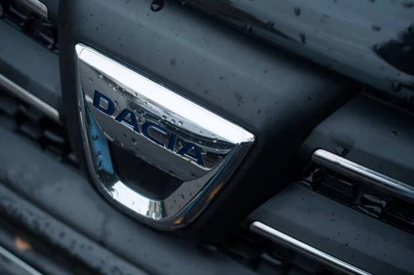 Regen druppels op Dacia logo op voorste auto geparkeerd in de straat — Stockfoto