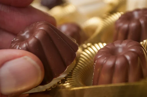 Primer plano de la mano del hombre tomando un Chocolate en forma de kouglofs — Foto de Stock