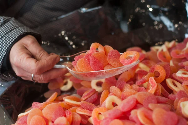 Hand van vrouw plukken snoepjes in een snoepgoed winkel — Stockfoto