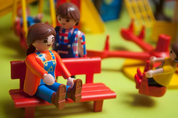 緑の背景に子供のための遊び場でのPlaymobil人形 — ストック写真