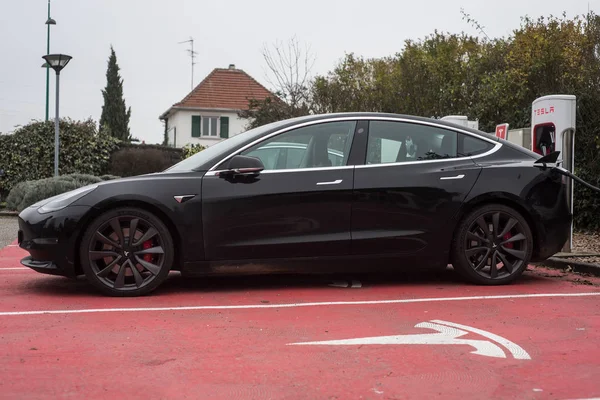 Черный автомобиль Tesla припарковался на зарядной станции Tesla — стоковое фото