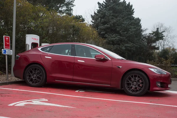 Красный автомобиль Тесла припаркован на станции нагнетателя Тесла — стоковое фото