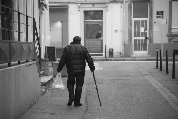 Porträtt på baksidan av ols man promenader med pinne på gatan — Stockfoto