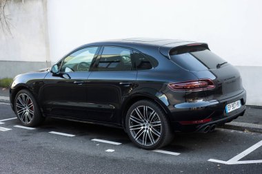  Siyah Porsche Macan Turbo 'nun profil görüntüsü sokağa park edilmiş. 