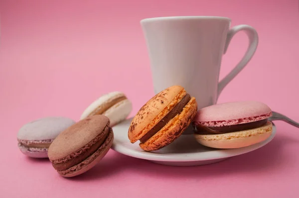 Closeup of french macarons and cup of coffee on pink background — Stock Photo, Image