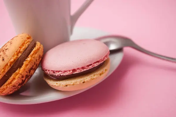 Primer plano de macarrones franceses y taza de café sobre fondo rosa —  Fotos de Stock