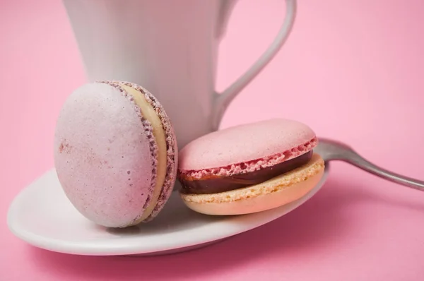 Primo piano di macaron francesi e tazza di caffè su sfondo rosa — Foto Stock