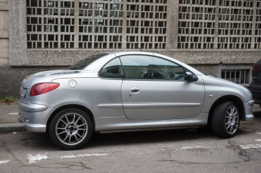 Gri Peugeot 206 CC 'nin profil görüntüsü sokağa park edilmiş.