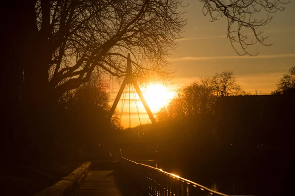 Panorama mit Silhouette der Hängebrücke unter dem Kanal und Baumsilhouetten bei Sonnenuntergang — Stockfoto