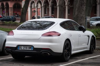 Rear view of white Porsche parked in the street