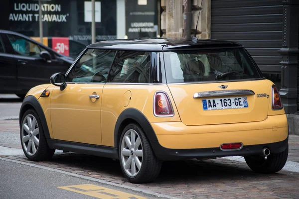 Achteraanzicht van gele mini cooper D geparkeerd in de straat — Stockfoto