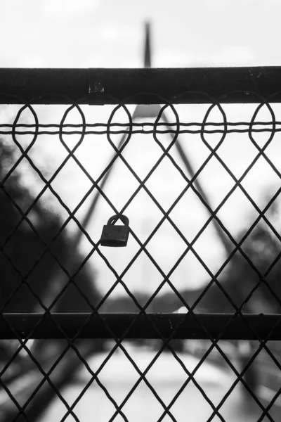 Close-up de cadeado de amor na cerca metálica no fundo paisagem turva em preto e branco — Fotografia de Stock