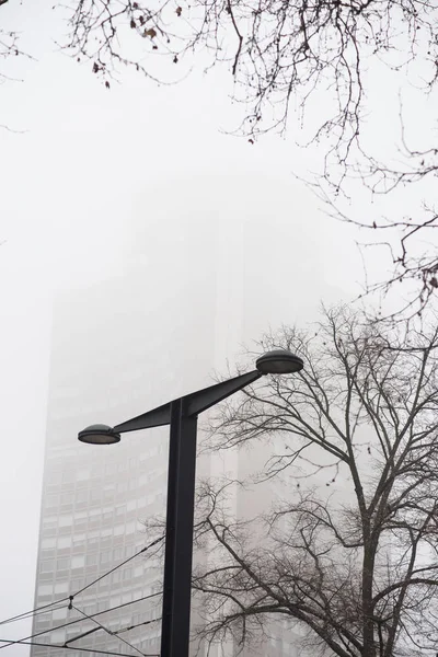 Modern street lamp with europe tower on background by foggy day — Stock Photo, Image