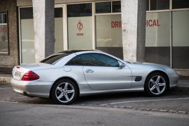 Caddeye park edilmiş gri Mercedes Benz 500sl 'in profil görüntüsü 