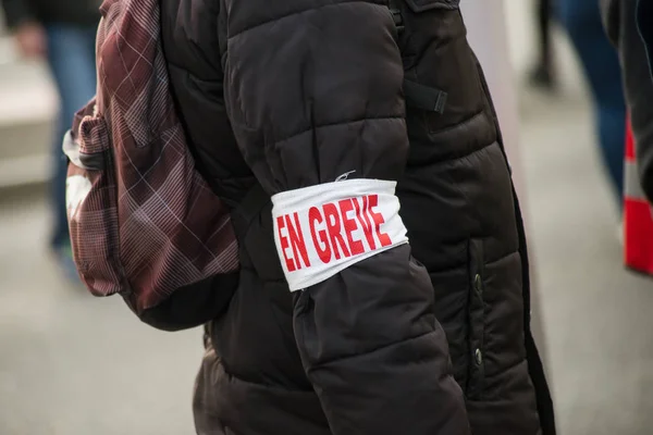 Persone che protestano in strada con bracciale scrittura greve in francese, traduction in inglese: sciopero — Foto Stock