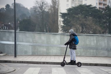 Sokakta elektrikli scooter 'ın üzerinde duran kadın portresi 