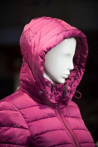 pink winter coat on mannequin in a fashion store showroom for women