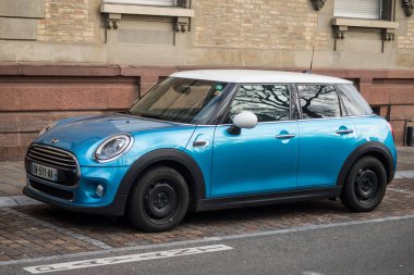 Mavi mini Cooper 'ın profil görüntüsü sokağa park edilmiş.