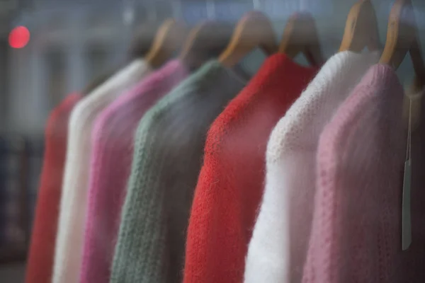 Крупный план красочной коллекции шерстяных пуловеров на вешалках — стоковое фото
