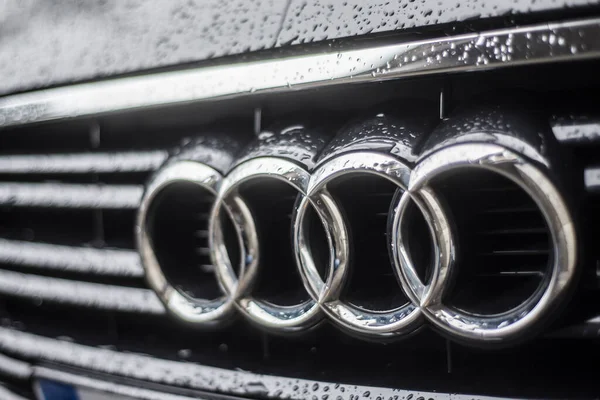 Gotas de lluvia en el logotipo de Audi en el coche negro estacionado en la calle — Foto de Stock