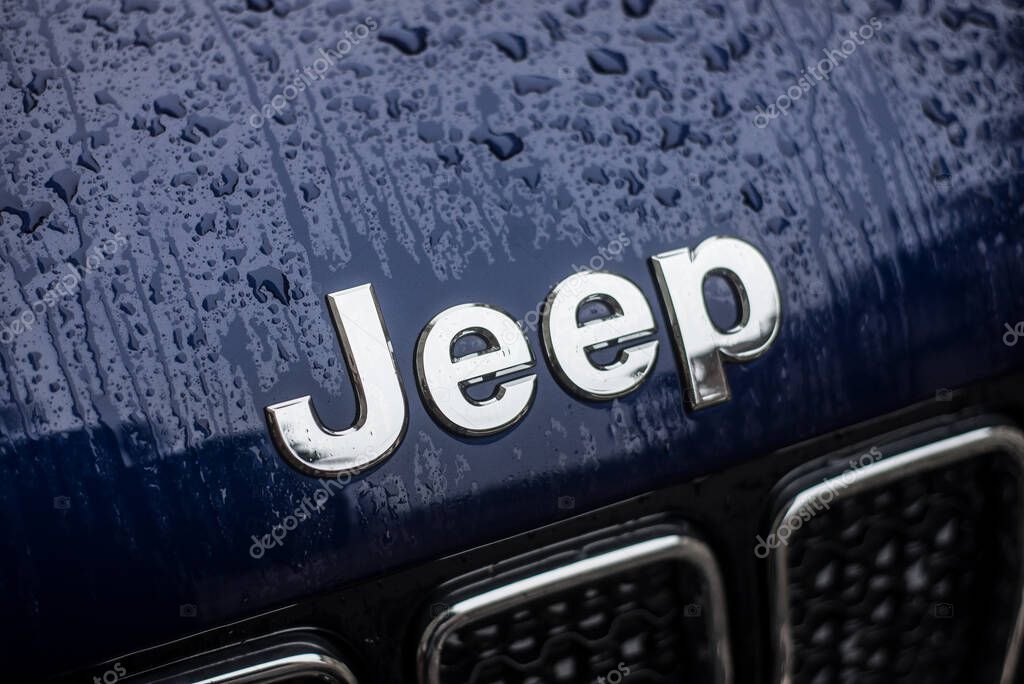 Mulhouse - France - 2 February 2020 - closeup of rain drops on Jeep logo on blue car parked in the street